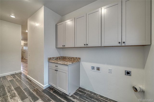 clothes washing area featuring hookup for a washing machine, dark hardwood / wood-style floors, electric dryer hookup, and cabinets