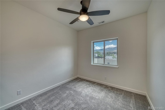 carpeted spare room featuring ceiling fan