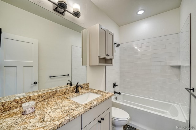 full bathroom with vanity, tiled shower / bath combo, and toilet