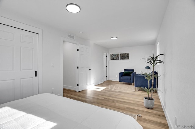 bedroom with visible vents, baseboards, and wood finished floors