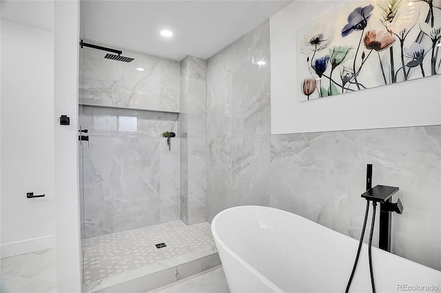 bathroom featuring marble finish floor, a freestanding tub, a shower stall, and visible vents