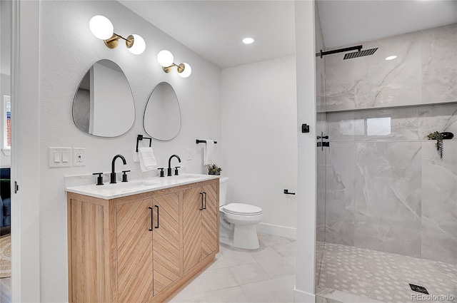 bathroom with toilet, double vanity, a sink, and a marble finish shower