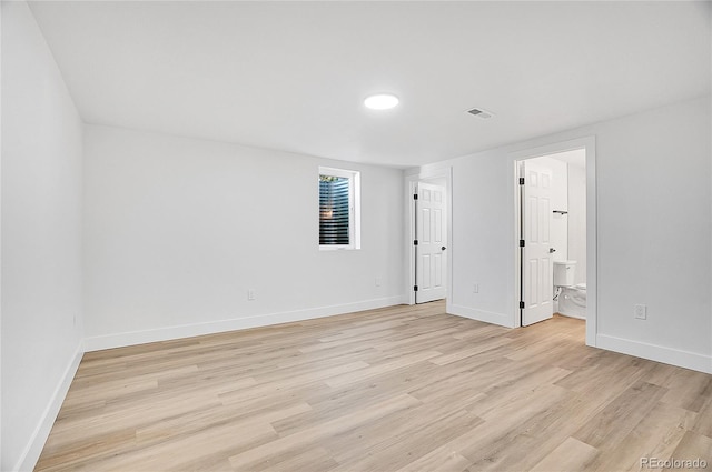 unfurnished room featuring light wood-type flooring, baseboards, and visible vents