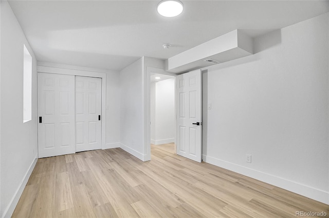 interior space with light wood finished floors, visible vents, and baseboards