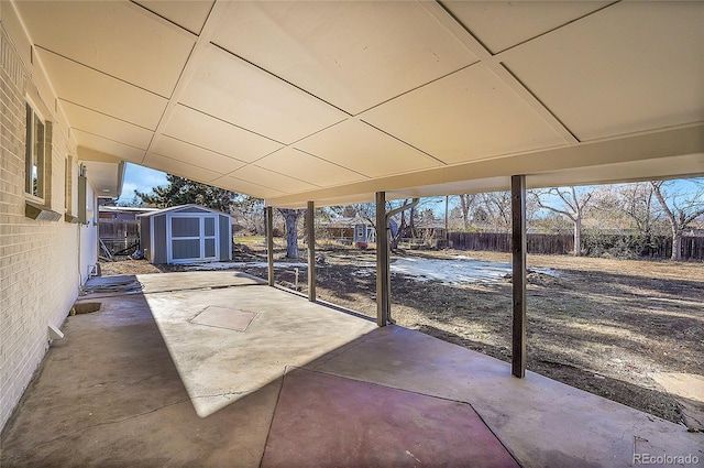 view of patio with a fenced backyard, a storage unit, and an outbuilding