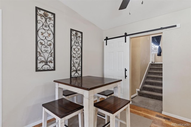 5220 Topaz Dr, Colorado Springs, CO 80918 - dining room with baseboards, ceiling fan, light wood-style flooring, a barn door, and stairway