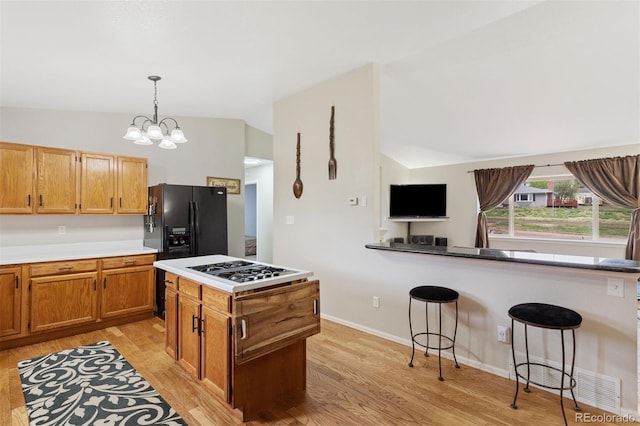 5220 Topaz Dr, Colorado Springs, CO 80918 - kitchen with vaulted ceiling, light wood-style flooring, white gas cooktop, and black refrigerator with ice dispenser