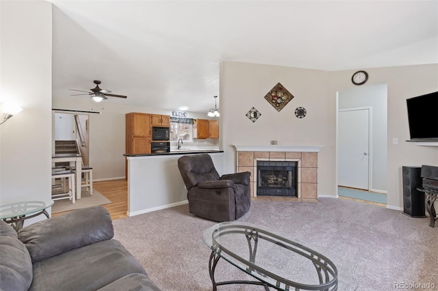 5220 Topaz Dr, Colorado Springs, CO 80918 - living room with light colored carpet, a ceiling fan, a fireplace, and baseboards