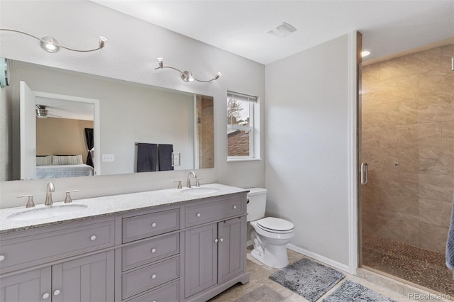 5220 Topaz Dr, Colorado Springs, CO 80918 - ensuite bathroom featuring a stall shower, toilet, double vanity, tile patterned floors, and baseboards