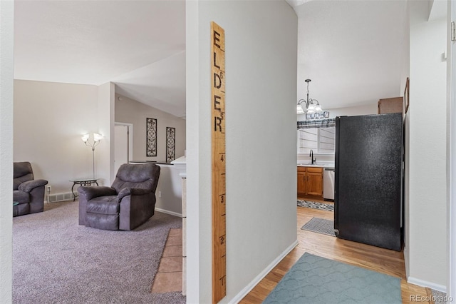 5220 Topaz Dr, Colorado Springs, CO 80918 - hall with a chandelier, lofted ceiling, a sink, and baseboards