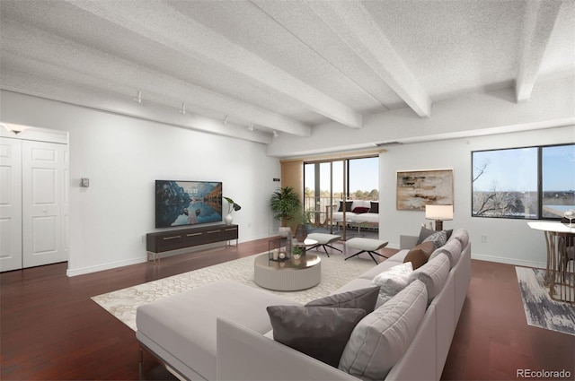 living room featuring dark hardwood / wood-style flooring, a textured ceiling, and beam ceiling