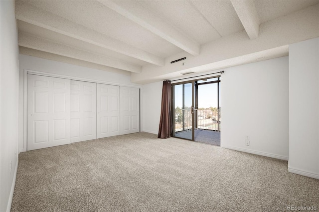 unfurnished bedroom with beam ceiling, carpet floors, a textured ceiling, and access to outside