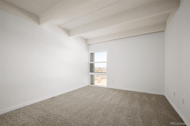 unfurnished room with beamed ceiling, carpet, and a textured ceiling