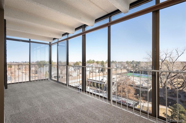 unfurnished sunroom featuring beamed ceiling