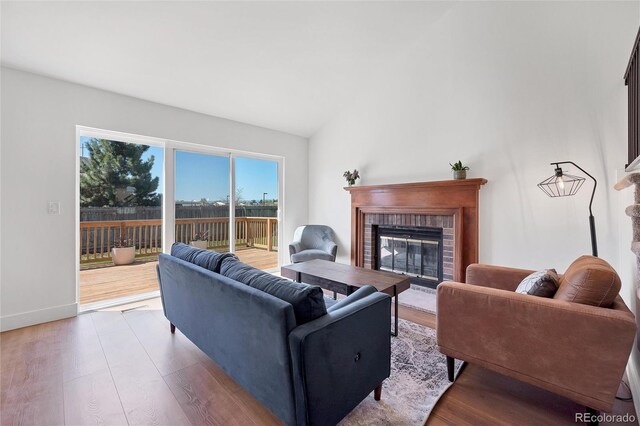 714 Sedge Way, Lafayette, CO 80026 - living area with a fireplace, wood finished floors, lofted ceiling, and baseboards