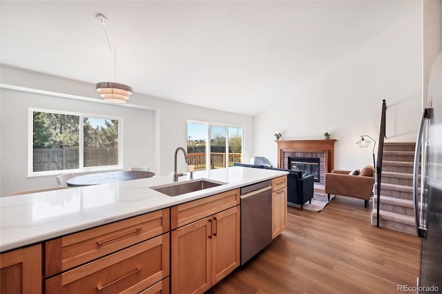 714 Sedge Way, Lafayette, CO 80026 - kitchen featuring a sink, stainless steel appliances, a fireplace, wood finished floors, and light countertops