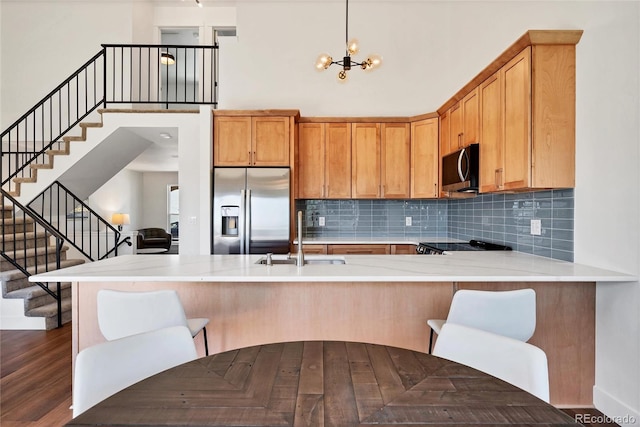 714 Sedge Way, Lafayette, CO 80026 - kitchen featuring appliances with stainless steel finishes, a sink, a high ceiling, light countertops, and a peninsula