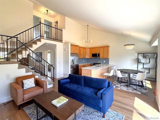 714 Sedge Way, Lafayette, CO 80026 - living area featuring baseboards, light wood-style floors, stairs, and high vaulted ceiling