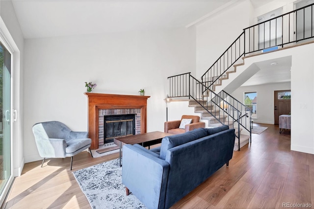 714 Sedge Way, Lafayette, CO 80026 - living area featuring healthy amount of natural light, wood finished floors, stairway, a brick fireplace, and a towering ceiling