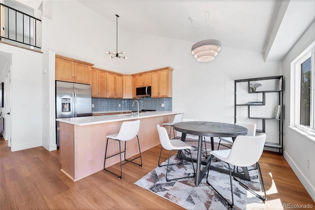 714 Sedge Way, Lafayette, CO 80026 - kitchen featuring appliances with stainless steel finishes, a peninsula, backsplash, light countertops, and wood finished floors