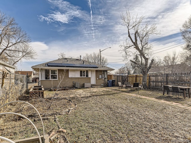 rear view of house featuring solar panels