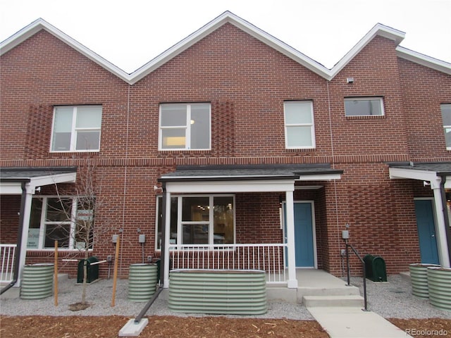 view of front of home with brick siding and covered porch