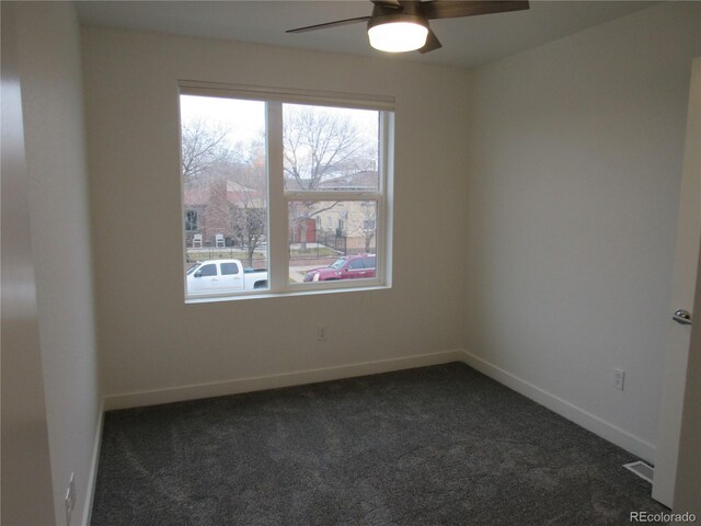 unfurnished room with ceiling fan, dark colored carpet, and a healthy amount of sunlight