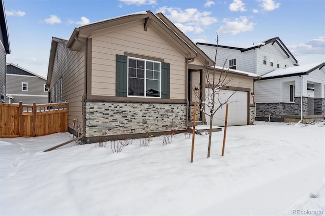 snow covered rear of property featuring a garage