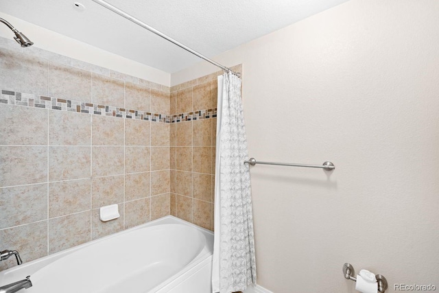 bathroom with shower / bath combination with curtain and a textured ceiling