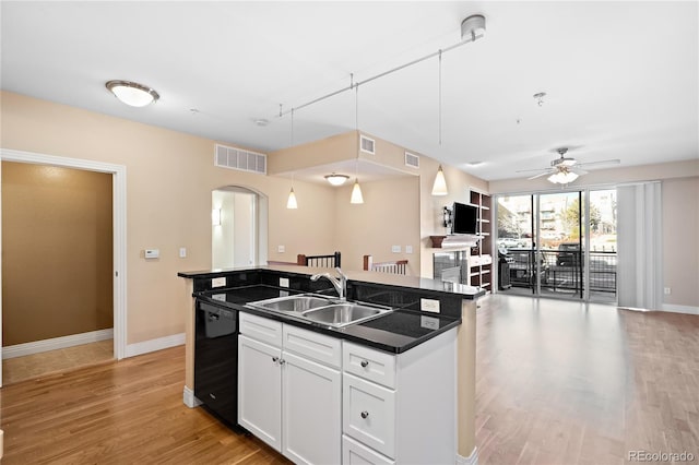 9019 E Panorama Cir Unit D211, Englewood, CO 80112 - kitchen featuring black dishwasher, arched walkways, dark countertops, open floor plan, and a kitchen island with sink
