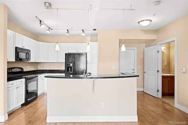 kitchen with black appliances, white cabinets, hanging light fixtures, and light hardwood / wood-style flooring