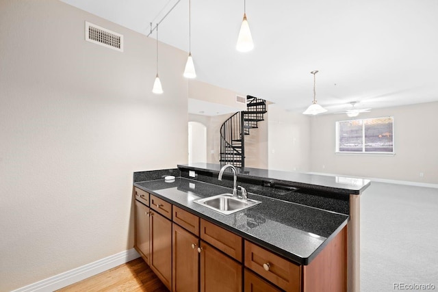 9019 E Panorama Cir Unit D211, Englewood, CO 80112 - kitchen featuring a peninsula, brown cabinets, open floor plan, pendant lighting, and ceiling fan