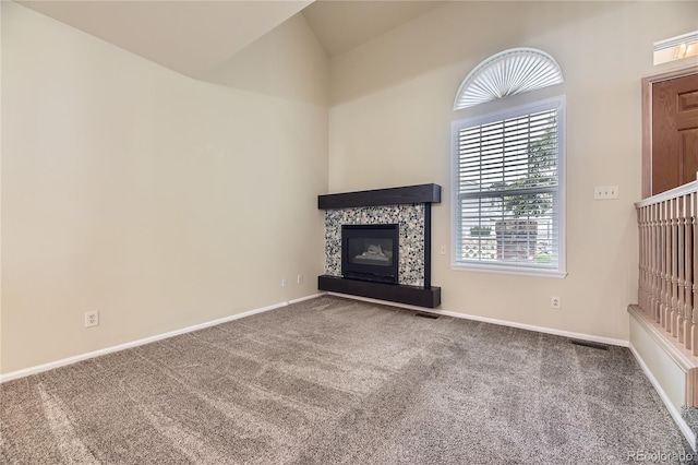 2902 W Long Cir Unit B, Littleton, CO 80120 - unfurnished living room with a fireplace, carpet, baseboards, and vaulted ceiling