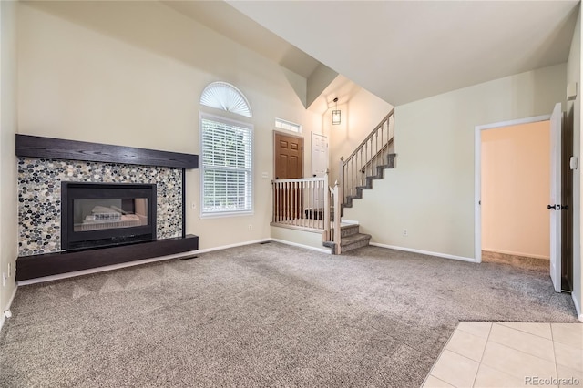 2902 W Long Cir Unit B, Littleton, CO 80120 - unfurnished living room with carpet floors, a fireplace, baseboards, stairway, and a towering ceiling