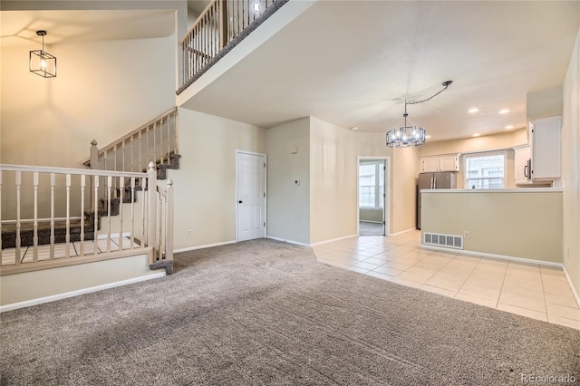 2902 W Long Cir Unit B, Littleton, CO 80120 - unfurnished living room with a chandelier, light colored carpet, stairs, baseboards, and recessed lighting