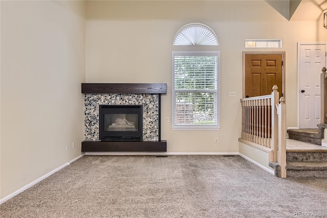 2902 W Long Cir Unit B, Littleton, CO 80120 - unfurnished living room with carpet, a tiled fireplace, and baseboards
