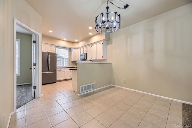 2902 W Long Cir Unit B, Littleton, CO 80120 - kitchen with stainless steel appliances, a chandelier, light tile patterned floors, white cabinets, and baseboards