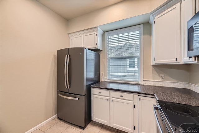 2902 W Long Cir Unit B, Littleton, CO 80120 - kitchen featuring freestanding refrigerator, white cabinetry, light tile patterned floors, dark stone countertops, and baseboards