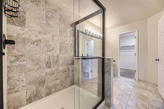 2902 W Long Cir Unit B, Littleton, CO 80120 - bathroom featuring a shower stall, a textured ceiling, and a spacious closet