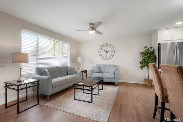 living room featuring ceiling fan and light hardwood / wood-style floors