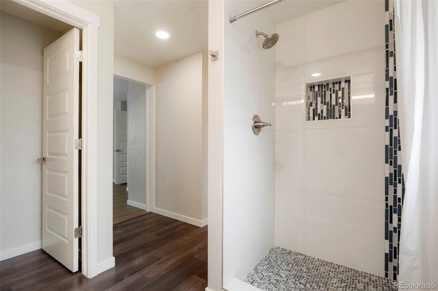 bathroom featuring hardwood / wood-style flooring and tiled shower