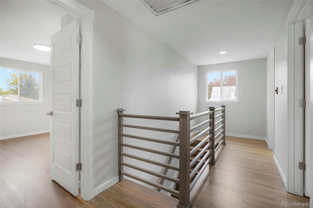 staircase with hardwood / wood-style floors and a healthy amount of sunlight