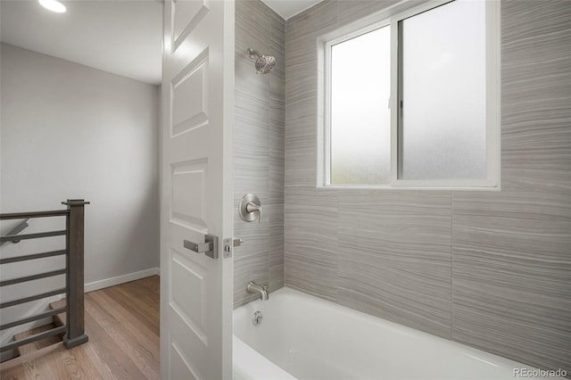 bathroom with hardwood / wood-style floors and tiled shower / bath