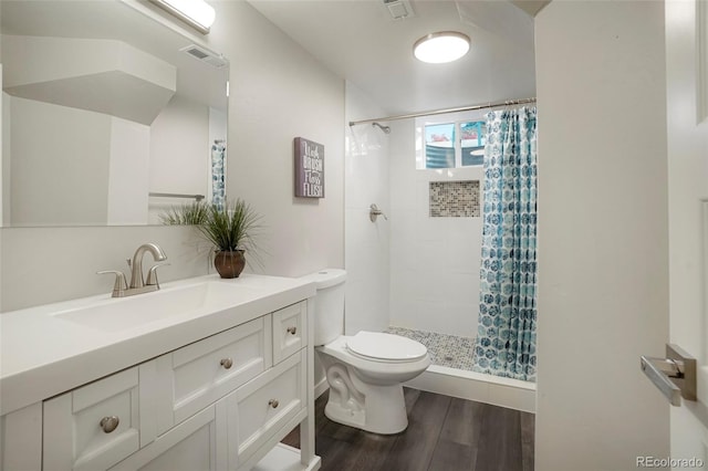 bathroom featuring hardwood / wood-style flooring, vanity, toilet, and walk in shower