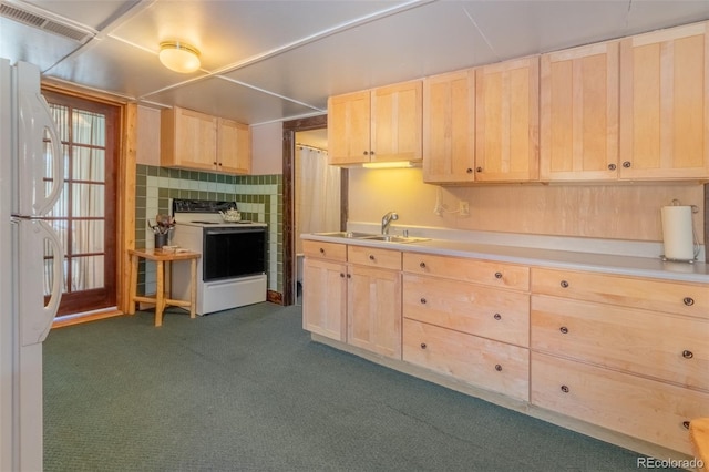 kitchen with light brown cabinets, dark carpet, white appliances, and sink