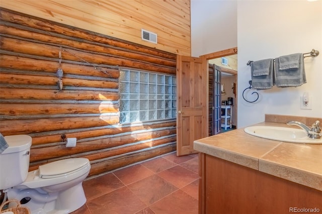 bathroom with log walls, tile patterned floors, vanity, and toilet