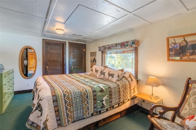 carpeted bedroom with a paneled ceiling