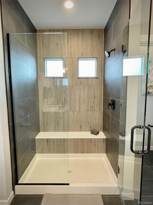 bathroom featuring tile patterned floors and a shower with shower door