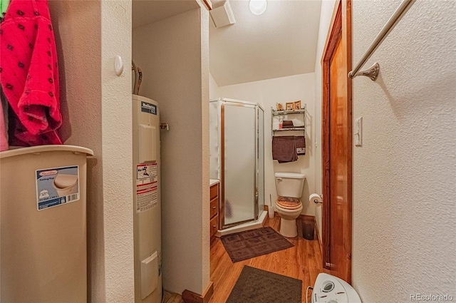 bathroom with wood finished floors, a stall shower, water heater, toilet, and lofted ceiling