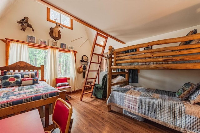 bedroom with lofted ceiling and wood finished floors